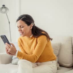 Woman listening to an audiobook through her hearing aids.