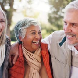 Happy group of friends laughing and hugging outdoors.