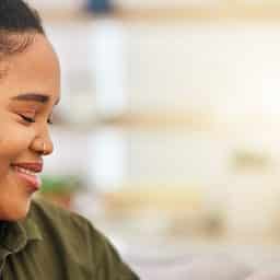 Sideview of woman with hearing aids with eyes closed and smiling
